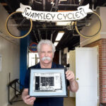 Chip Wamsley with photo of first shop